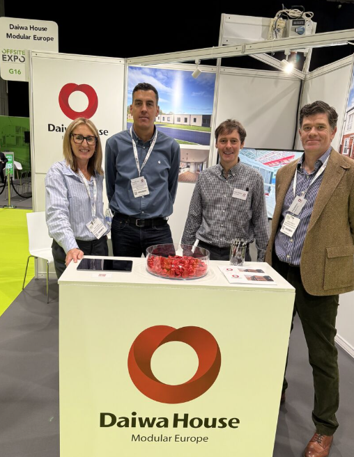 UK team of Daiwa House Modular Europe standing next to a table at the Offsite Expo in Coventry the largest exhibition for modular construction