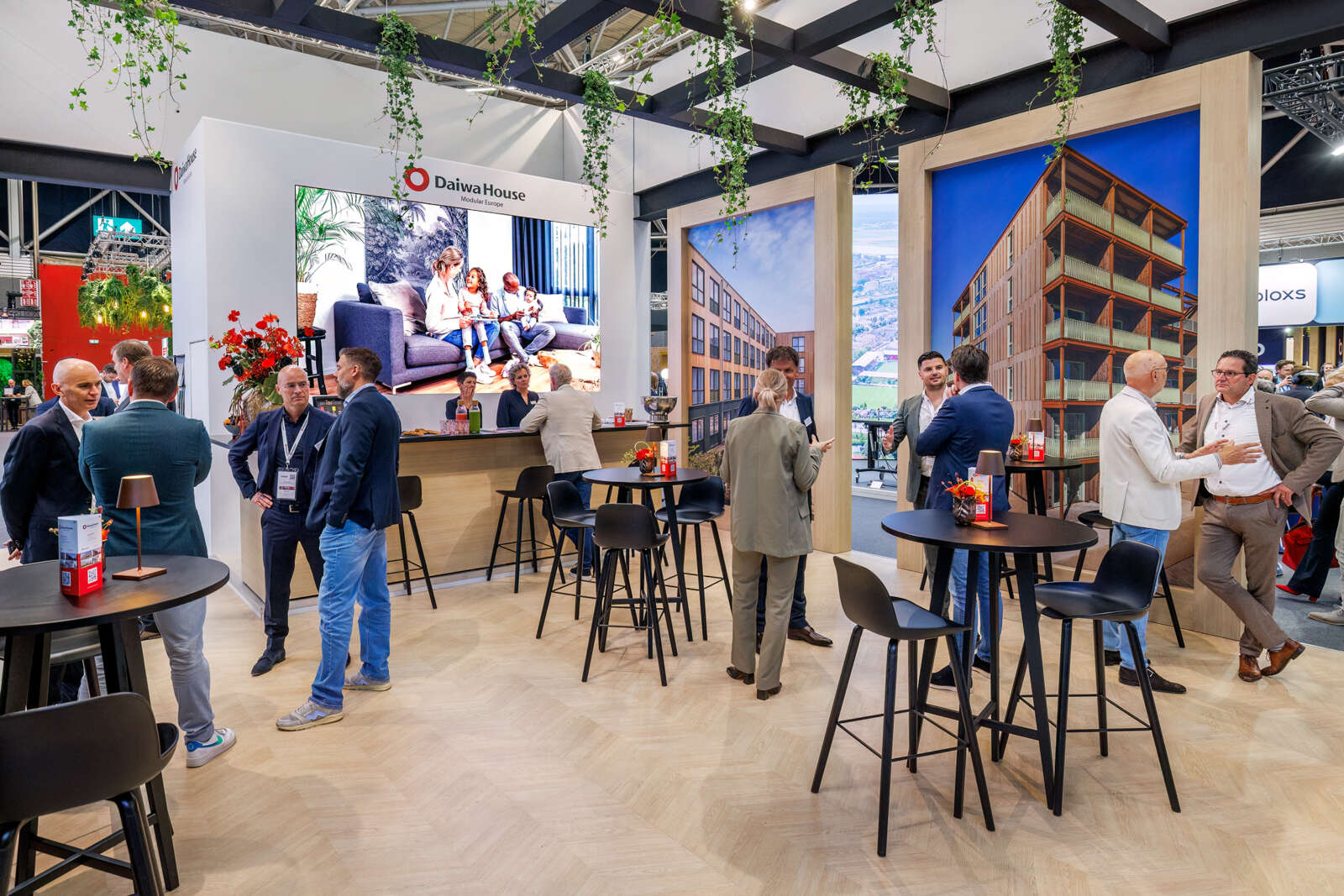 Bezoekers ontmoeten elkaar op de stand van Daiwa House Modular Europe.